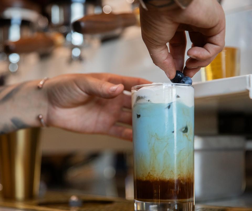 Johnny Rios places blueberries as the final touch of an order of "The Slopes" inside The Coffee Builders in Phoenix on Aug. 9, 2023.