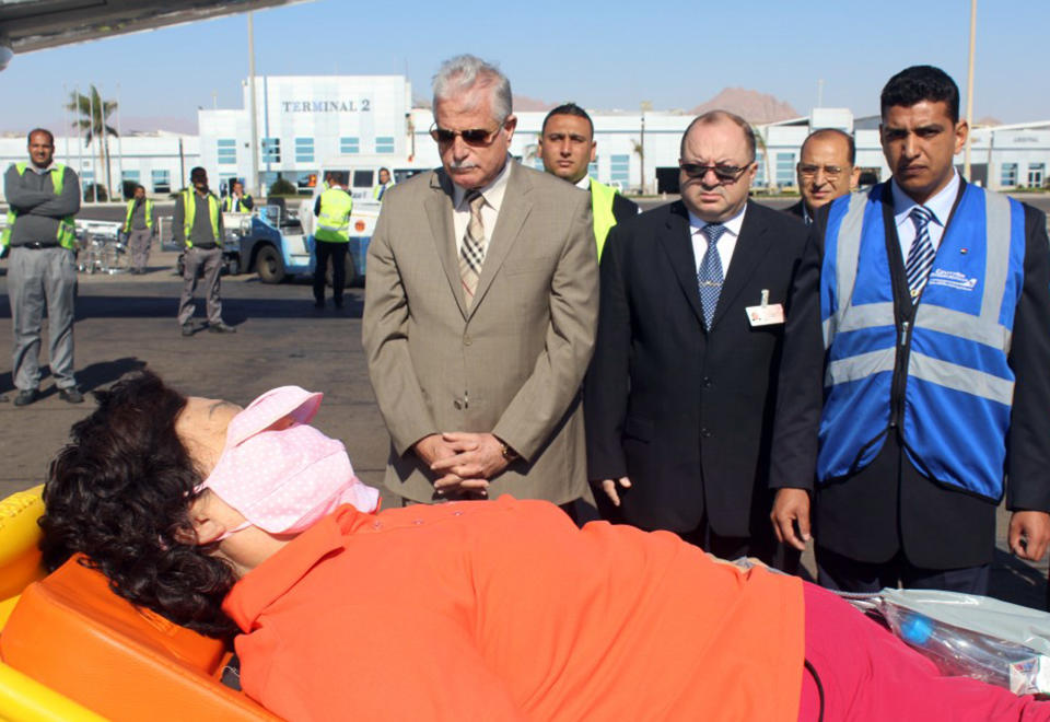 In this photo released by the Office of the South Sinai Governor, the governor of South Sinai, Major General Khaled Foda, center left, and other officials, watch as a South Korean tourist who was wounded in a deadly blast Sunday, on a bus in Taba, is evacuated to her home country, at Sharm el Sheikh airport, Egypt, Wednesday, Feb. 19, 2014. The bombing Sunday was the first targeting foreign tourists in the Sinai in nearly decade, raising fears that Islamic militants who have been waging a campaign of violence against security forces in the peninsula are now turning to attack tourism, a pillar of Egypt's economy. (AP Photo/Office of the South Sinai Governor)