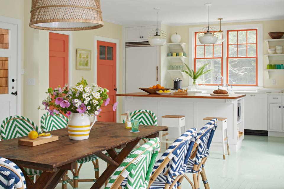 <p>In the expanded kitchen, window frames and interior doors in coral help distinguish the work core from the family dining area.</p>