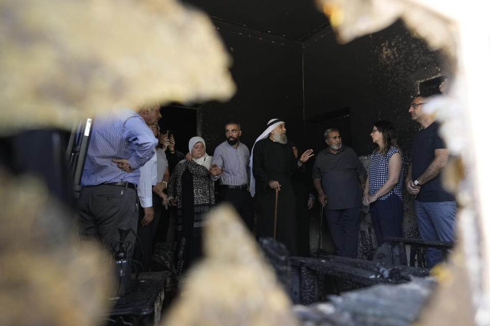 Palestinians speak to an international delegation touring the West Bank town of Turmus Ayya, days after a rampage by Jewish settlers, Friday, June 23, 2023. Israeli settlers entered the town, setting fire to Palestinian cars and homes after four Israelis were killed by Palestinian gunmen in the northern West Bank on Tuesday. (AP Photo/Majdi Mohammed)