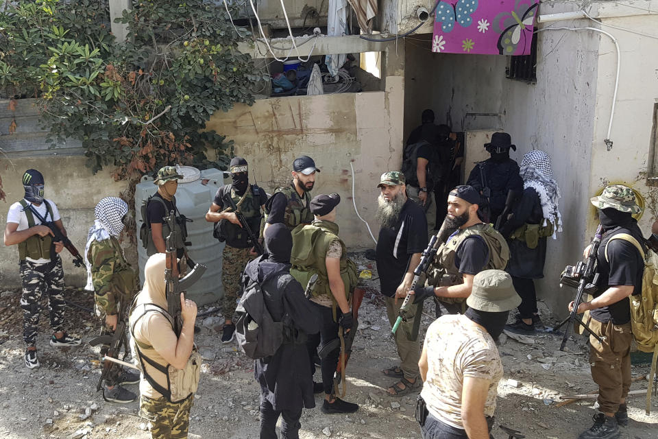 Members of Islamic militant factions gather in the Palestinian refugee camp of Ein el-Hilweh near the southern port city of Sidon, Lebanon, Friday, Sept. 29, 2023. A Palestinian security force deployed Friday in a school complex in Lebanon's largest Palestinian refugee camp in the country's south, replacing gunmen who had occupied it since fighting broke out in late July leaving more than 30 people dead. (AP Photo/Mohammed Zaatari)