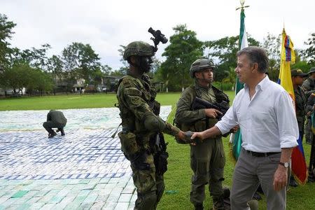 Colombia's President Juan Manuel Santos greets a soldier after the seizure of more than 12 tons of cocaine in Apartado, Colombia November 8, 2017. Colombian Presidency/Handout via REUTERS