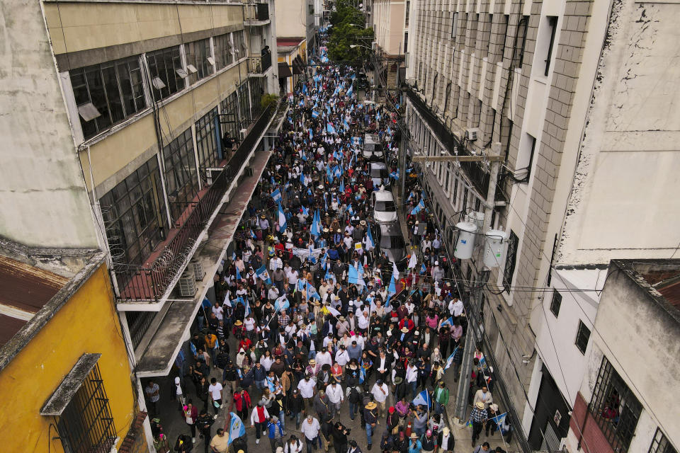 People accompany President-elect Bernardo Arévalo in a march in protest of government interference in the elections he won in August, in Guatemala City, Thursday, Dec. 7, 2023. Arévalo is set to take office on Jan. 14, 2024. (AP Photo/Moises Castillo)