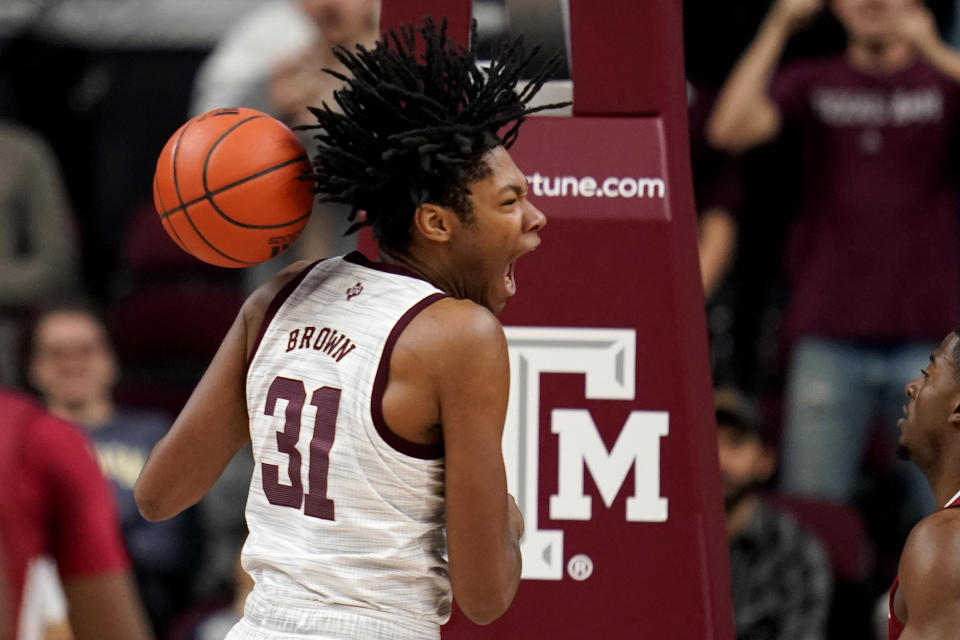 Texas A&M forward Javonte Brown (31) reacts after dunking the ball against Arkansas during the first half of an NCAA college basketball game Saturday, Jan. 8, 2022, in College Station, Texas. (AP Photo/Sam Craft)