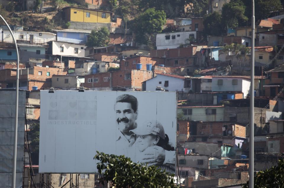 Esta fotografía del sábado 23 de mayo de 2020 muestra un anuncio con la imagen del presidente venezolano Nicolás Maduro y la primera dama Cilia Flores en el barrio de Catia, en Caracas, Venezuela. (AP Foto/Ariana Cubillos)