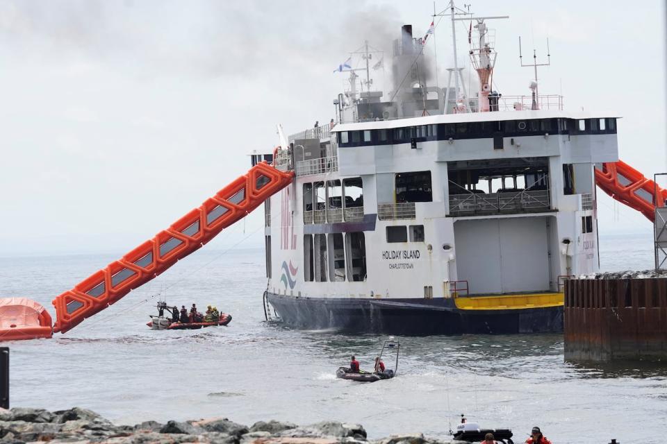 Fire fighters approach the MV Holiday Island ferry after a fire broke out on it, in Wood Islands, Prince Edward Island, Canada on Friday. 