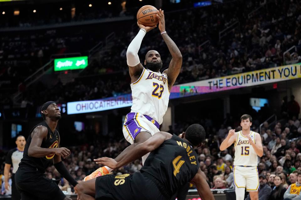 Lakers forward LeBron James shoots over Cavaliers forward Evan Mobley during the first half, Saturday, Nov. 25, 2023, in Cleveland.