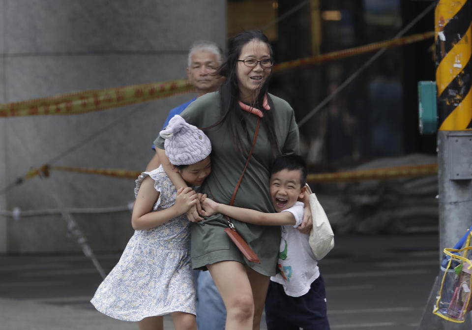 People struggle to walk against gusts of wind generated by Typhoon Haikui in Taipei, Taiwan, Sunday, Sept. 3, 2023. (AP Photo/Chiang Ying-ying)