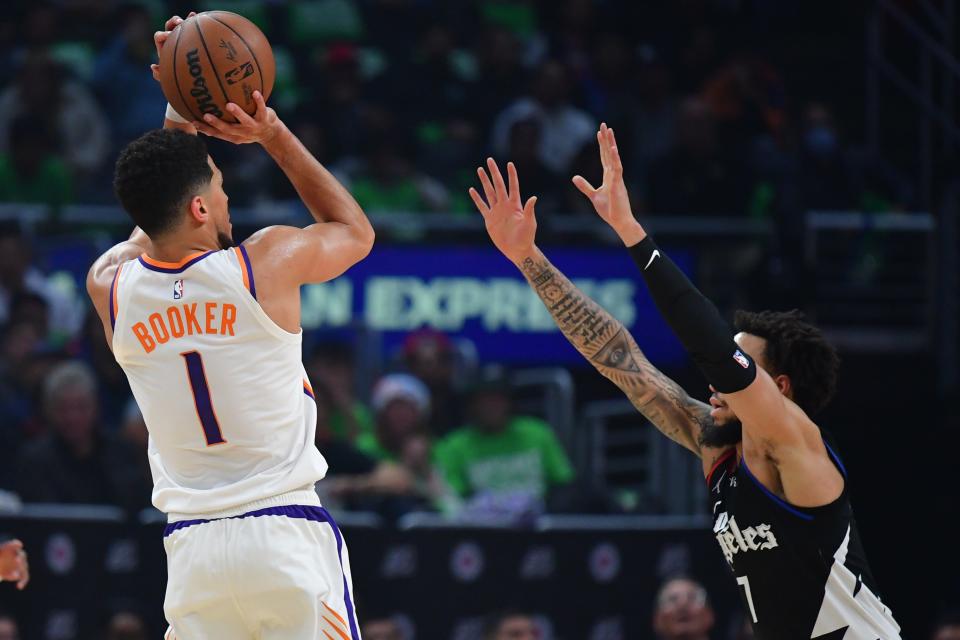 Dec 15, 2022; Los Angeles, California, USA; Phoenix Suns guard Devin Booker (1) shoots against Los Angeles Clippers guard Amir Coffey (7) during the first half at Crypto.com Arena. Mandatory Credit: Gary A. Vasquez-USA TODAY Sports