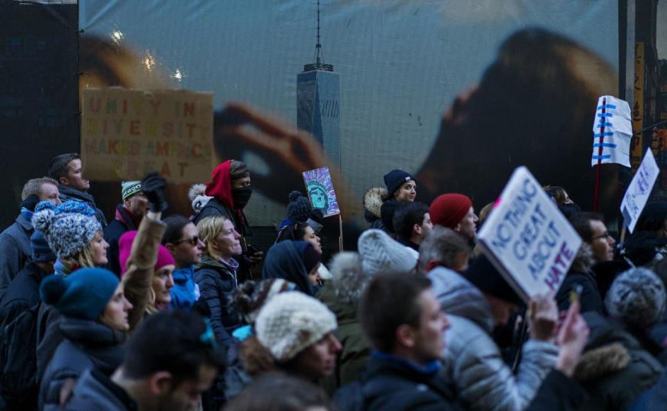With an image of One World Trade Center in the background, people march in New York, Sunday, Jan. 29, 2017, as they protest against President Donald Trump's executive order banning travel to the U.S. by citizens of several countries. (AP Photo/Craig Ruttle)