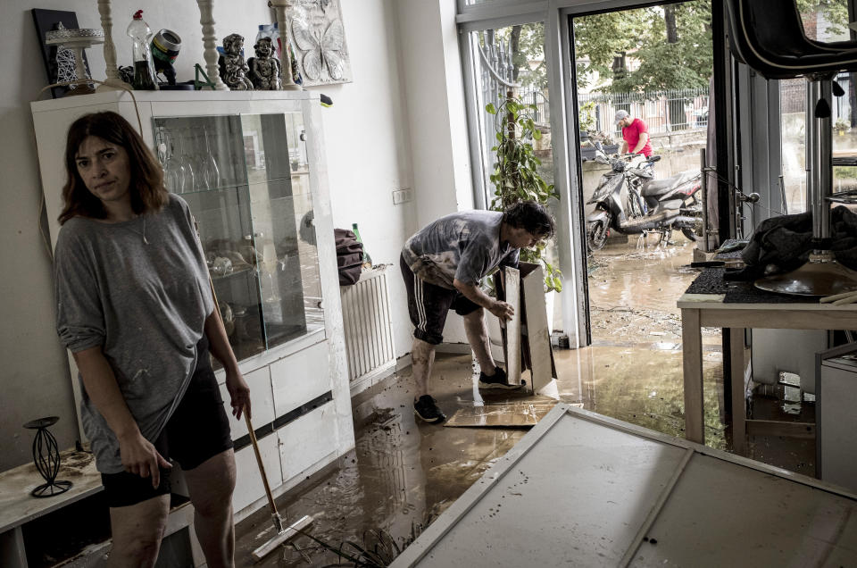 Homeowners push mud and water out of their house after flooding in Angleur, Province of Liege, Belgium, Friday July 16, 2021. Severe flooding in Germany and Belgium has turned streams and streets into raging torrents that have swept away cars and caused houses to collapse. (AP Photo/Valentin Bianchi)