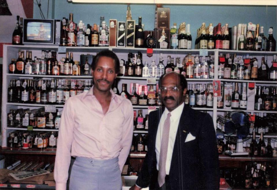 Larry Jackson Sr. (right) poses for a photo with his son, Larry Jackson Jr. (left), in his liquor store.