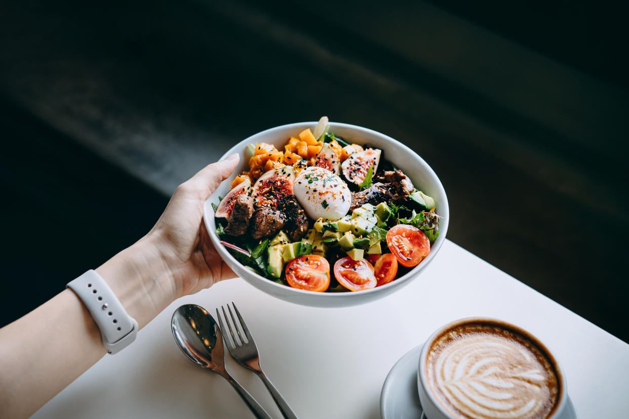 Close up of a salad bowl in a woman's hand