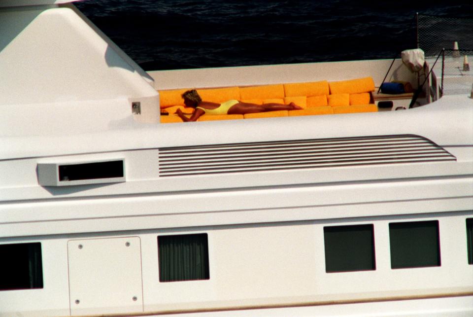 Princess Diana sunbathes on an orange couch aboard Jonikal.
