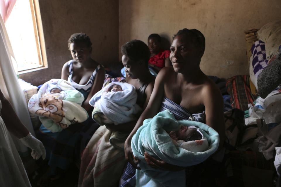 Mothers hold their babies delivered in a tiny apartment in the poor suburb of Mbare in Harare, Zimbabwe, Saturday, Nov. 16, 2019, with the help of 72-year old grandmother Esther Zinyoro Gwena. Grandmother Esther Zinyoro Gwena claims to be guided by the holy spirit and has become a local hero, as the country’s economic crisis forces closure of medical facilities, and mothers-to-be seek out untrained birth attendants.(AP Photo/Tsvangirayi Mukwazhi)