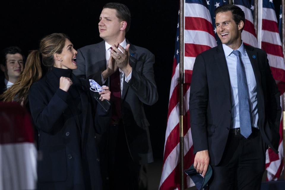 Three men and one woman look joyful onstage