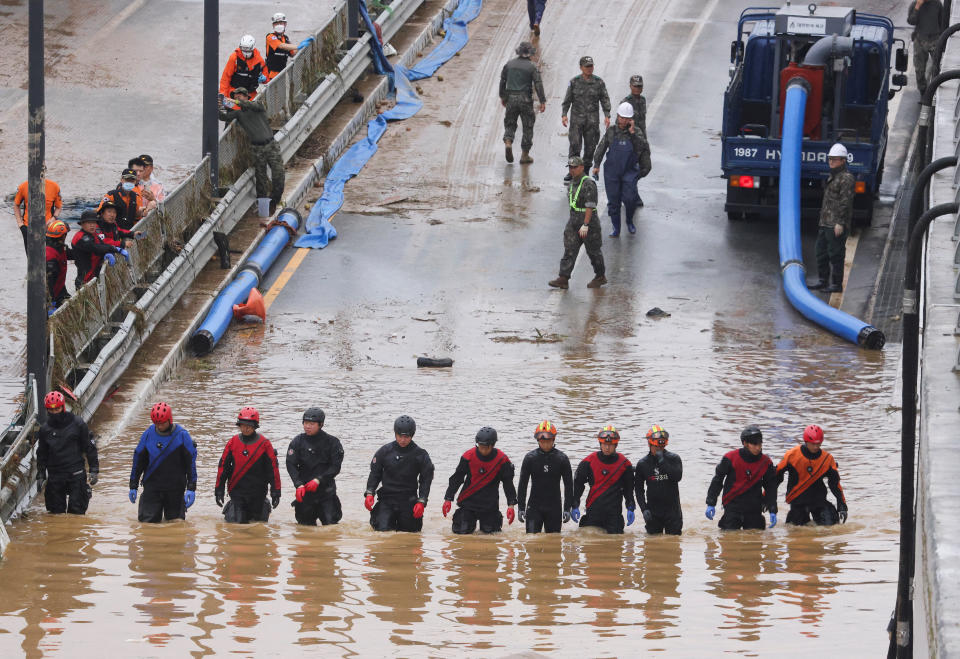 南韓救援人員16日在清州一條被暴雨淹沒的地下通道附近進行搜救行動。（路透社）