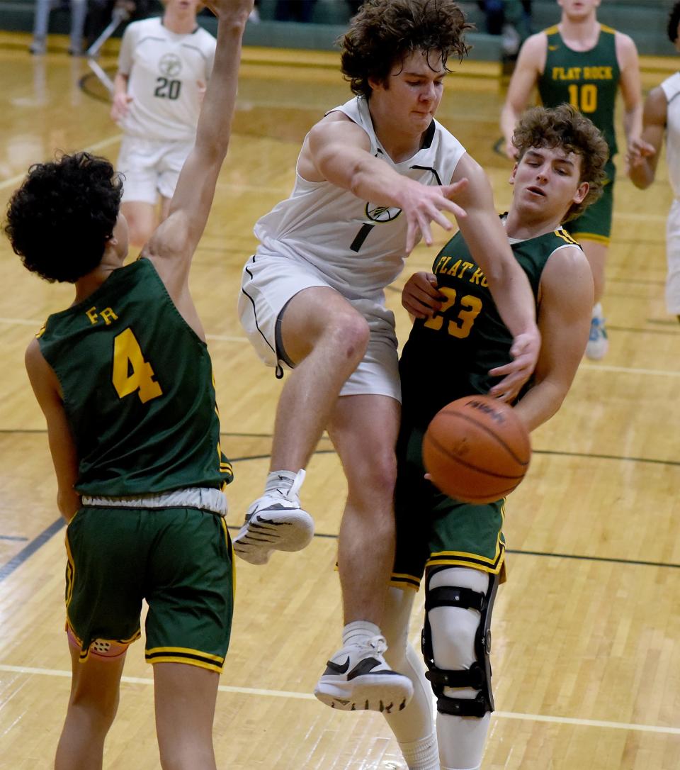 Brady Hines of St. Mary Catholic Central loses the ball under pressure from Graham Junge (23) and Cyrus Goins (4) of Flat Rock Tuesday, Jan. 9, 2024. Flat Rock won the game 50-39.
