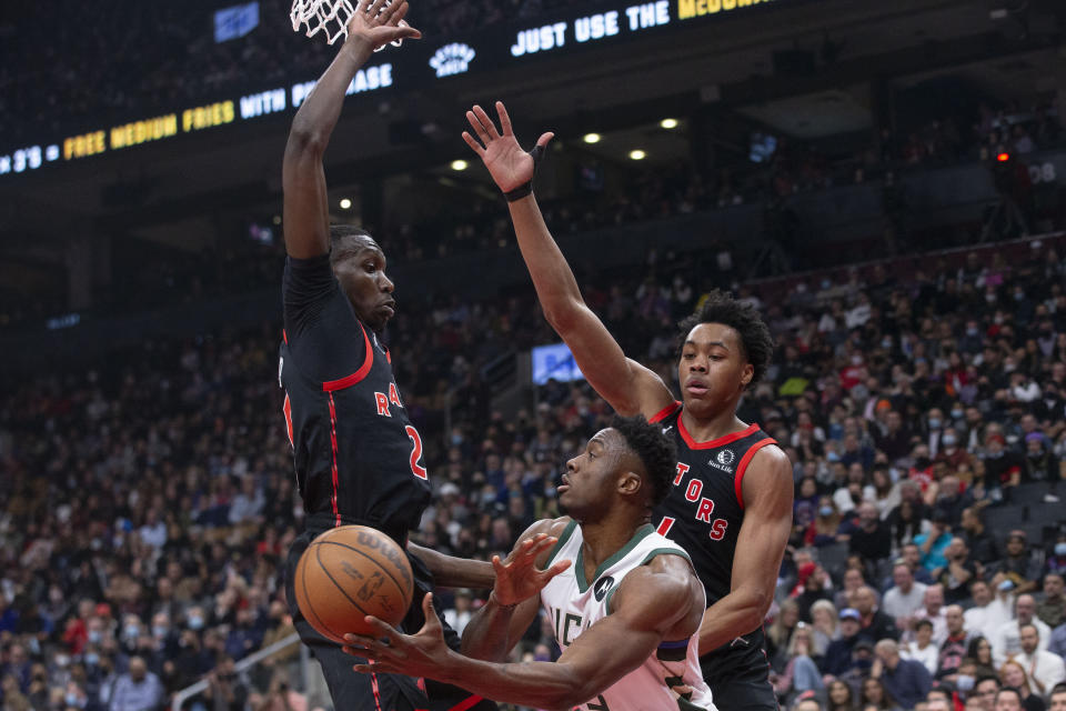 Milwaukee Bucks' Thanasis Antetokounmpo, lower right, looks to pass the ball away from Toronto Raptors' Chris Boucher, left, and Scottie Barnes during the first half of an NBA basketball game Thursday, Dec. 2, 2021, in Toronto. (Chris Young/The Canadian Press via AP)
