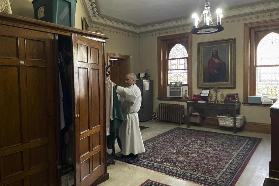 The Rev. Juan Eduardo Rodriguez, who later became pastor of St. Margaret Catholic Church, hangs his priestly vestments at St. Peter the Apostle Catholic Church in Reading, Pa., Wednesday June 12, 2024. Most of St. Peter the Apostle, and about two-thirds of Reading's 95,000 residents, are Latino. (AP Photo/Luis Andres Henao)