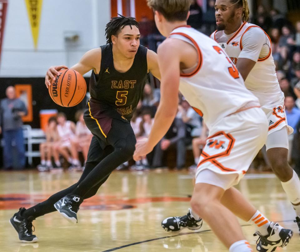 East Peoria's Justin Page (5) makes a move to the basket against Washington's Jamari White, background, and Jake Stewart in the second half Friday, Dec. 16, 2022 in Washington. The Raiders fell to the Panthers 52-45.