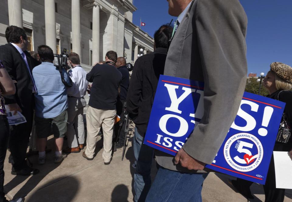 A man carries a sign showing support of a ballot measure that would legalize medical marijuana in the state at the Arkansas state Capitol in Little Rock, Ark., Thursday, Oct. 18, 2012. (AP Photo/Danny Johnston)