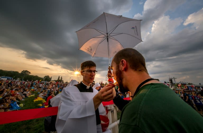A priest gives Holy Communion to a pilgrim during the opening mass for World Youth Day in Krakow, Poland, on July 26, 2016