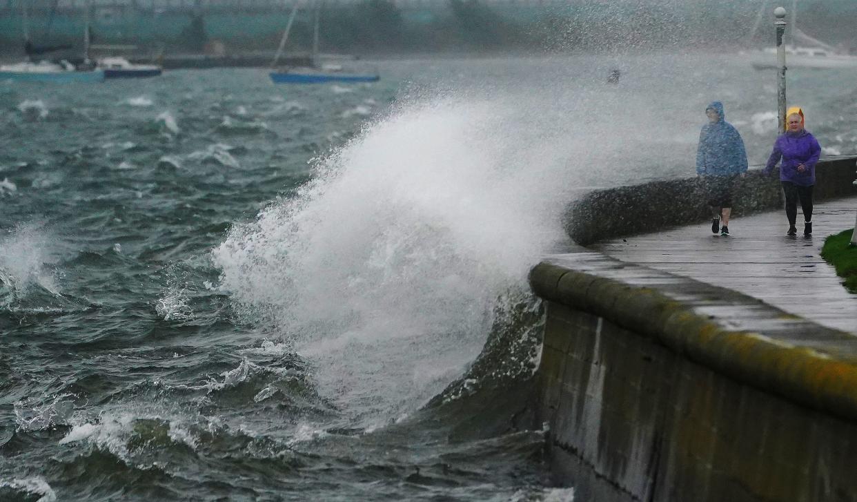 People walk along the Clontarf promenade, Dublin, as Storm Agnes lands (PA)