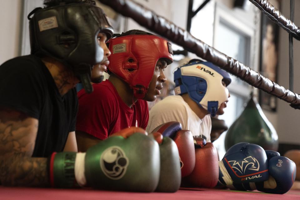 Boxers watch Theon Davis, 21, spar with another during training for his 176-pound Chicago Golden Gloves tournament boxing match at Garfield Park Boxing Wednesday, March 29, 2023, in Chicago. (AP Photo/Erin Hooley)