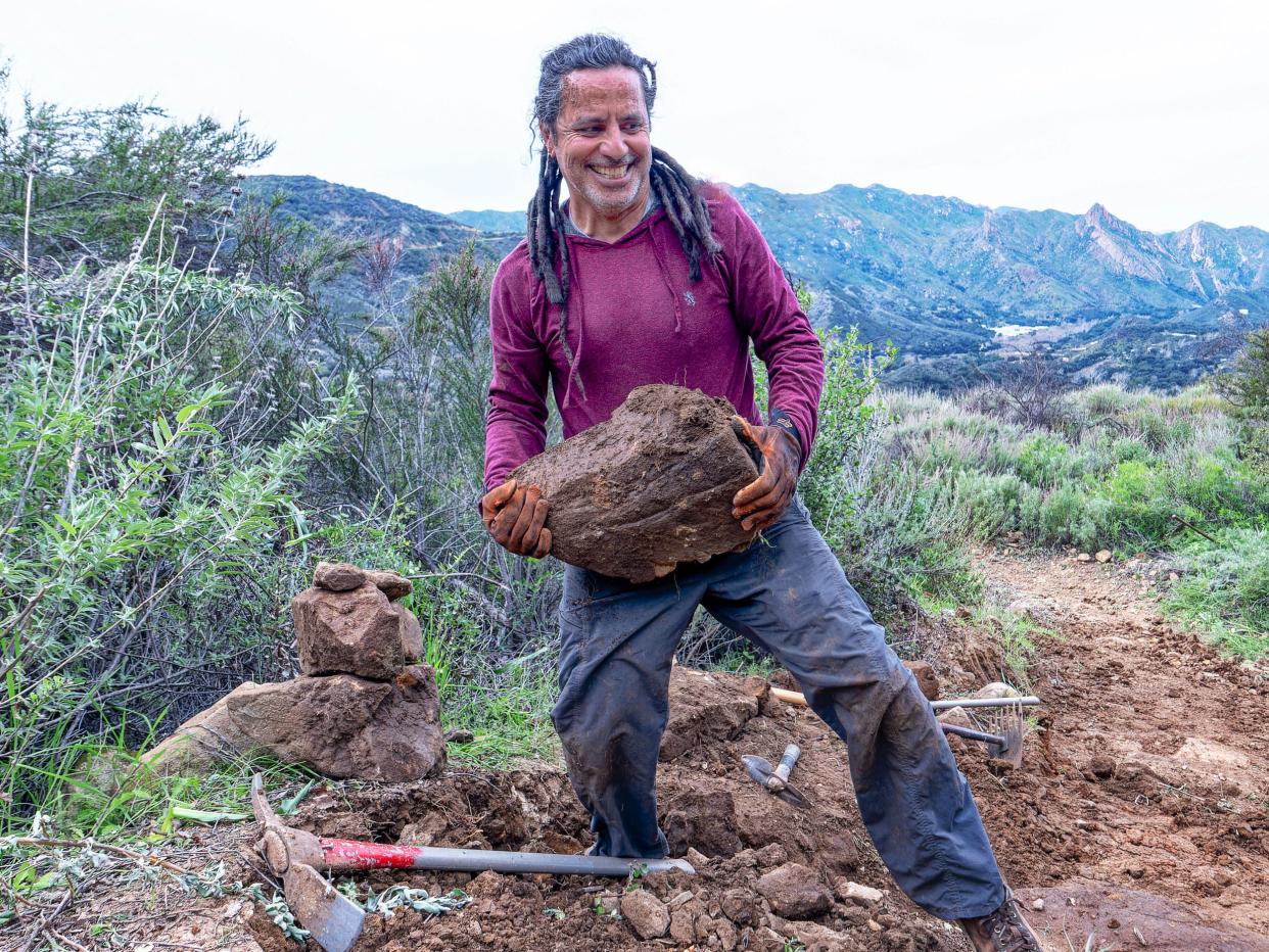 Juan Carlo, photographer with the Ventura County Star, picks up rocks to build steps at the Saddle Peak Trail in the Santa Monica Mountains. Juan Carlo said the pandemic rejuvenated the trails and altered his life.