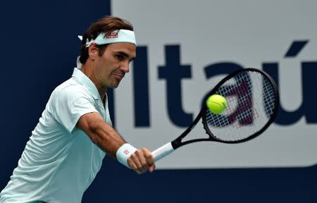 Mar 31, 2019; Miami Gardens, FL, USA; Roger Federer of Switzerland returns a shot back to John Isner of the United States during the men's finals at Miami Open Tennis Complex. Steve Mitchell-USA TODAY Sports