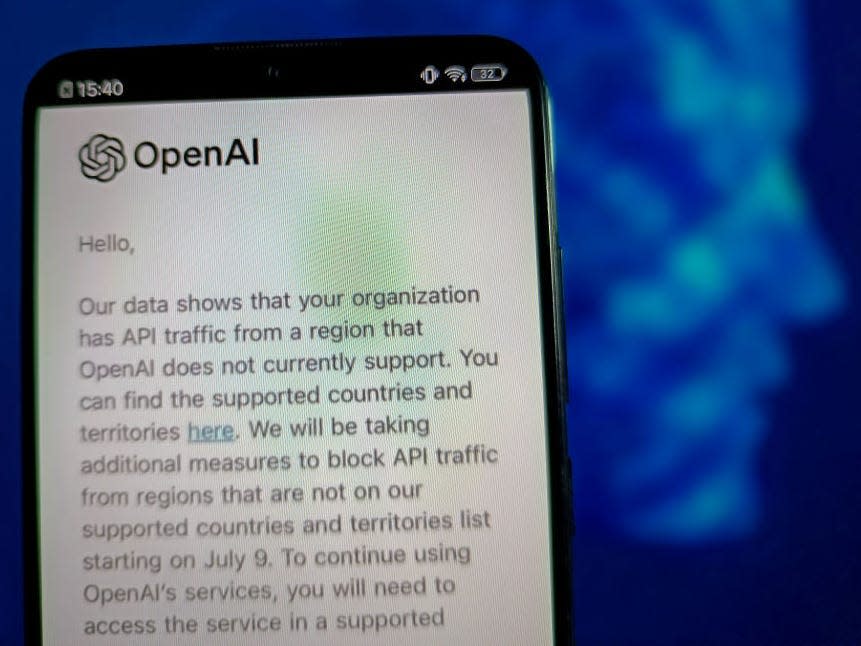 A cellphone showing the OpenAI logo and a block of nondescript text.