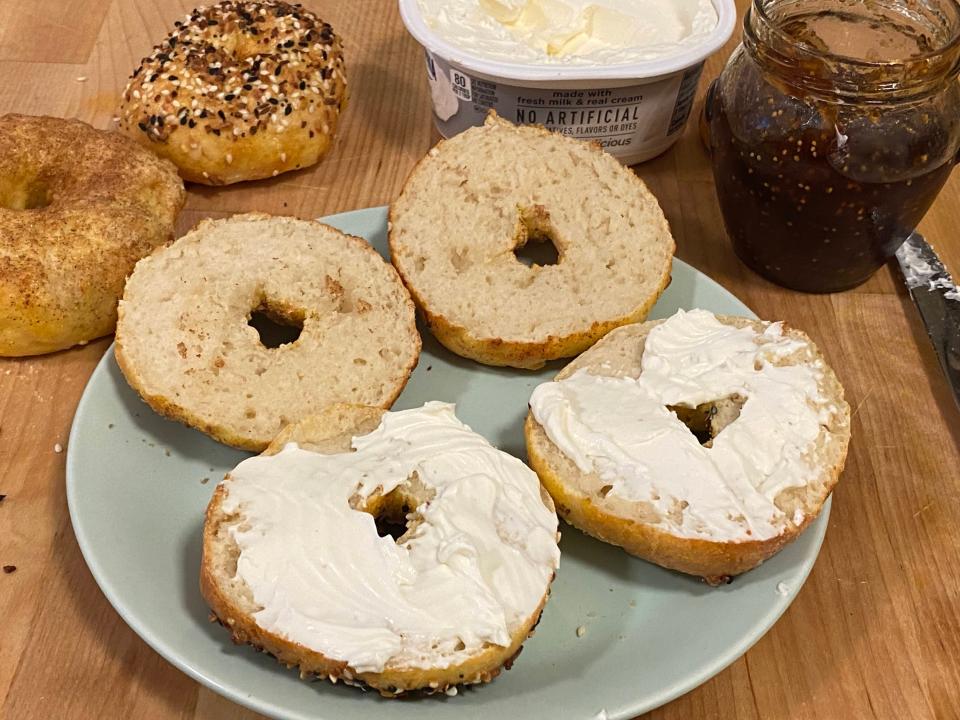 A photo of bagels spread with cream cheese on a plate.