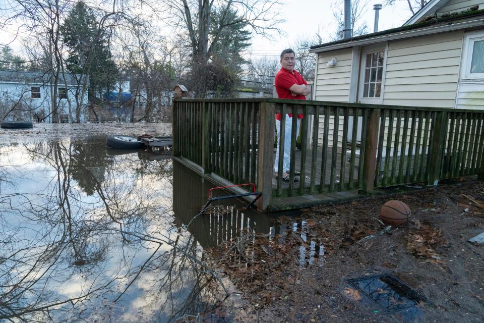 Freddy Ramigeo, of Wayne, looks over the flood water from his back porch on Fayette Ave in Wayne, NJ on Tuesday Dec. 19, 2023.