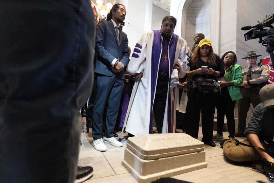 Rep. Justin Jones, D-Nashville, and Rev. William J. Barber leave a child's coffin at the door of the House chambers, Monday, April 17, 2023, in Nashville, Tenn. (AP Photo/George Walker IV)