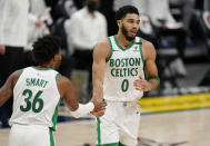 Boston Celtics guard Marcus Smart, left, congratulates forward Jayson Tatum after his basket against the Denver Nuggets in the second half of an NBA basketball game Sunday, April 11, 2021, in Denver. (AP Photo/David Zalubowski)