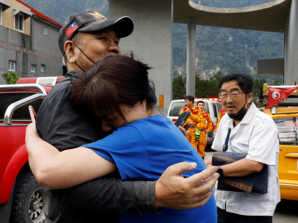 A relative hugs a man who was rescued (REUTERS)