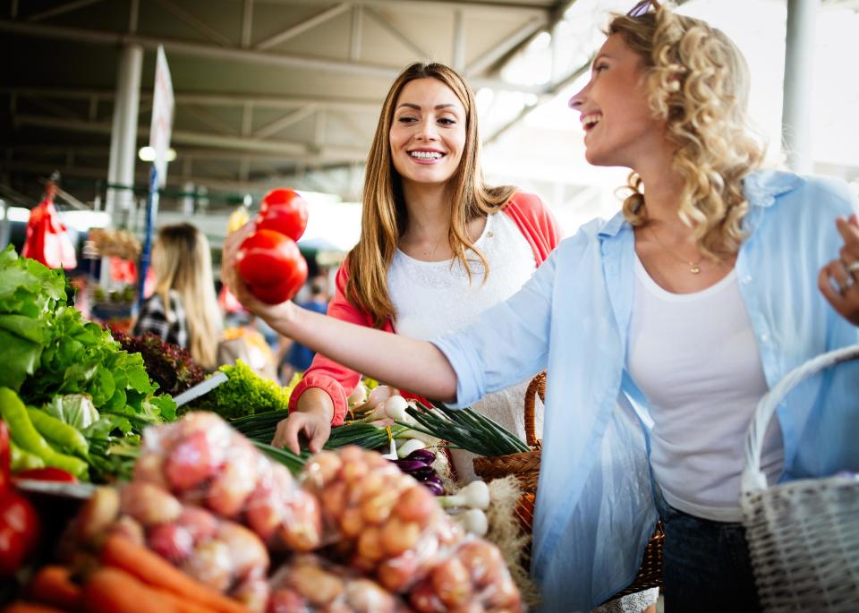 Young happy women shopping for vegetables and fruits.