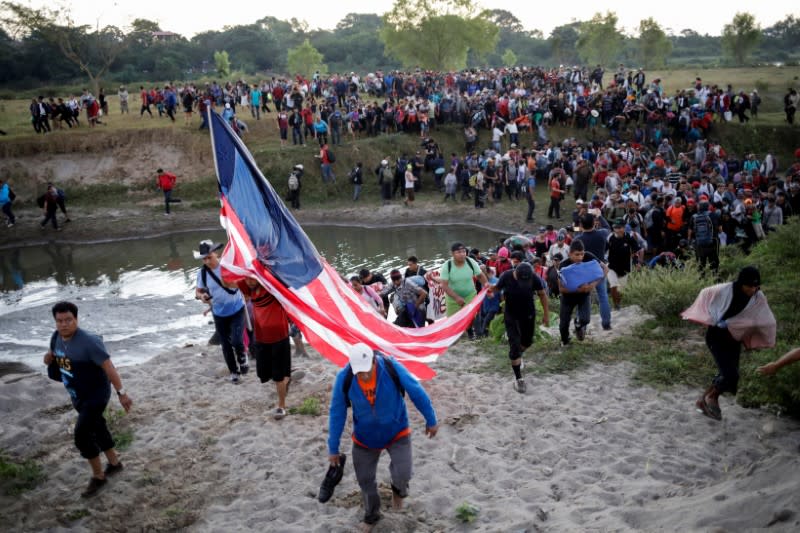 Migrants, mainly from Central America and marching in a caravan, walk after crossing the Suchiate river, on the outskirts of Ciudad Hidalgo