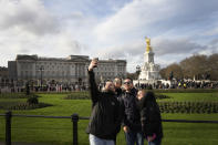 Tourists take a photograph in front of Buckingham Palace in London, Friday, Jan. 6, 2023. Prince Harry alleges in a much-anticipated new memoir that his brother Prince William lashed out and physically attacked him during a furious argument over the brothers' deteriorating relationship. The book "Spare" also included incendiary revelations about the estranged royal's drug-taking, first sexual encounter and role in killing people during his military service in Afghanistan. (AP Photo/Kirsty Wigglesworth)
