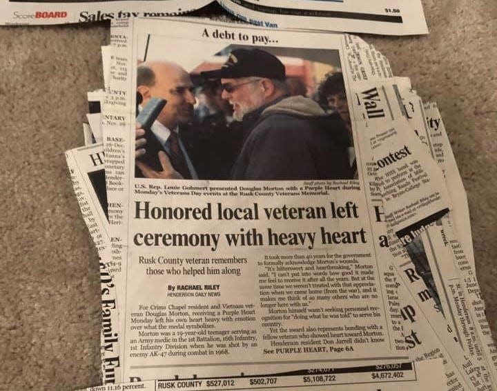 A newspaper clipping shows Vietnam veteran Douglas Moore receiving his Purple Heart in 2012. Another veteran, Don Jarrell, advocated for Moore's award.
