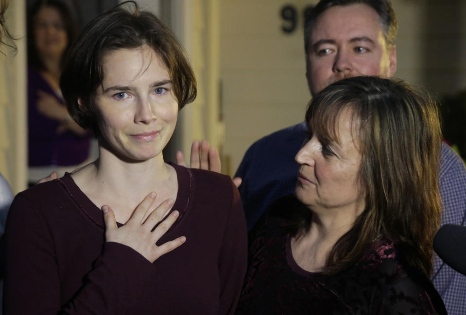 FILE - Amanda Knox, left, talks to reporters as her mother, Edda Mellas, right, looks on outside Mellas' home in Seattle, Friday, March 27, 2015. Amanda Knox faces yet another trial for slander in a case that could remove the last remaining guilty verdict against her eight years after Italy's highest court definitively threw out her conviction for the murder of her 21-year-old British roommate, Meredith Kercher. (AP Photo/Ted S. Warren, file)