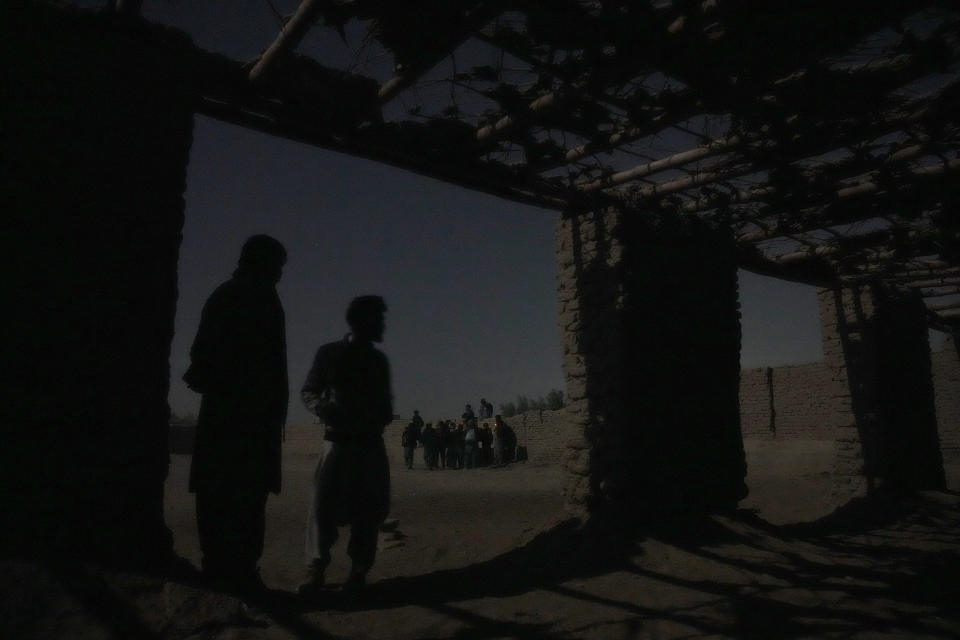 Young Shiite Afghan immigrants wait for midnight in ruins in the desert around the city of Zaranj, Afghanistan, near the the Iran-Afghanistan border wall, to try to cross over the Iranian border wall into Iran, Monday, Dec. 25, 2023. Every month, thousands cross into Iran at the border near Zaranj. It’s a risky route: In the dark of night, with the help of smugglers, they clamber over the border wall using ladders and jump down the other side. (AP Photo/Ebrahim Noroozi)