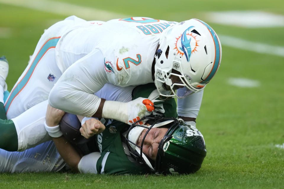 New York Jets quarterback Zach Wilson (2) grimaces after he is sacked by Miami Dolphins linebacker Bradley Chubb (2) during the first half of an NFL football game, Sunday, Dec. 17, 2023, in Miami Gardens, Fla. (AP Photo/Rebecca Blackwell)