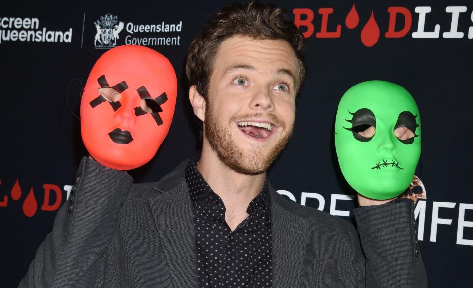 Jack Quaid attending the 'Tragedy Girls' Screamfest 2017 Los Angeles Premiere holding up two masks