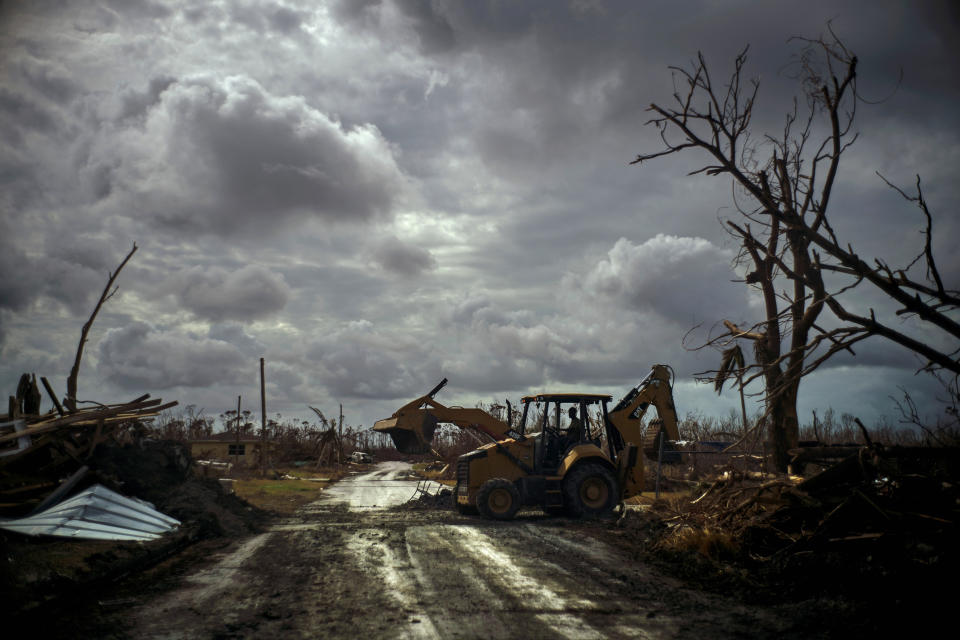 Mos Antenor, 42, drives a bulldozer while clearing the road after Hurricane Dorian Mclean's Town, Grand Bahama, Bahamas, Friday Sept. 13, 2019. (AP Photo/Ramon Espinosa)