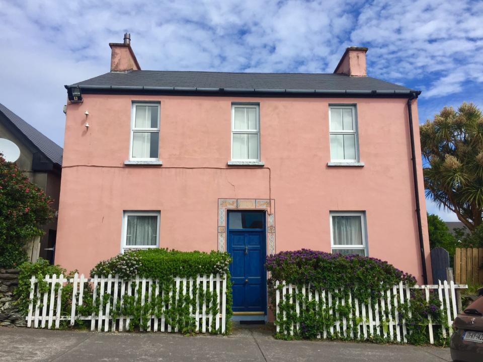 pink house with white fence and bushes in ireland