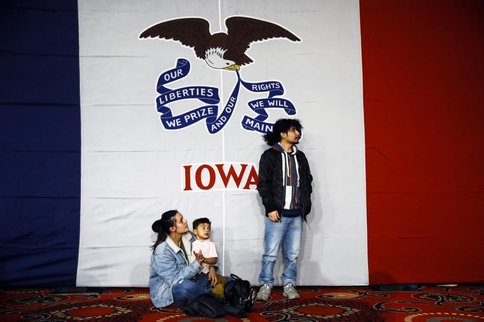 Natalie Serrano, left, and Isaac Garcia watch caucus returns come in with their son Leonel, 2, at a Democratic presidential candidate Sen. Bernie Sanders, I-Vt., caucus night campaign rally in Des Moines, Iowa, Monday, Feb. 3, 2020. (AP Photo/Matt Rourke)