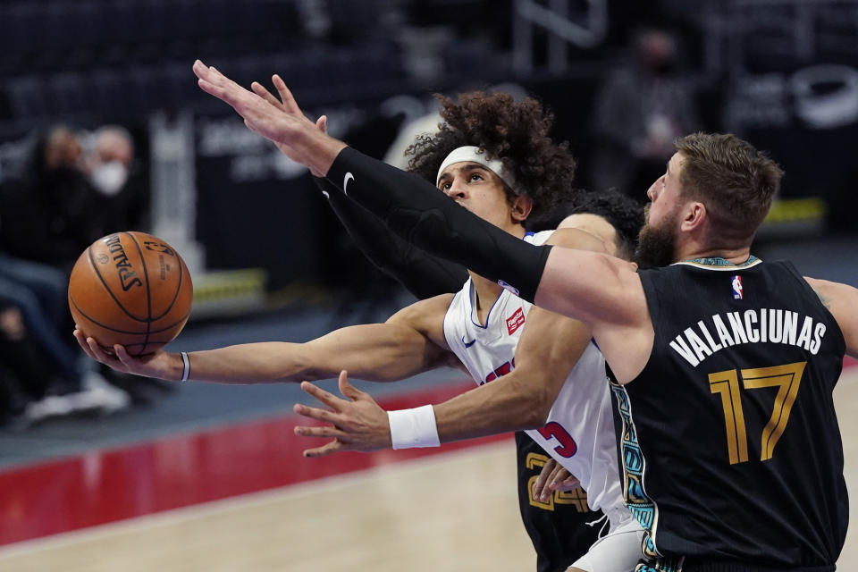 Detroit Pistons guard Frank Jackson (5) attempts a layup as Memphis Grizzlies center Jonas Valanciunas (17) defends during the first half of an NBA basketball game, Thursday, May 6, 2021, in Detroit. (AP Photo/Carlos Osorio)