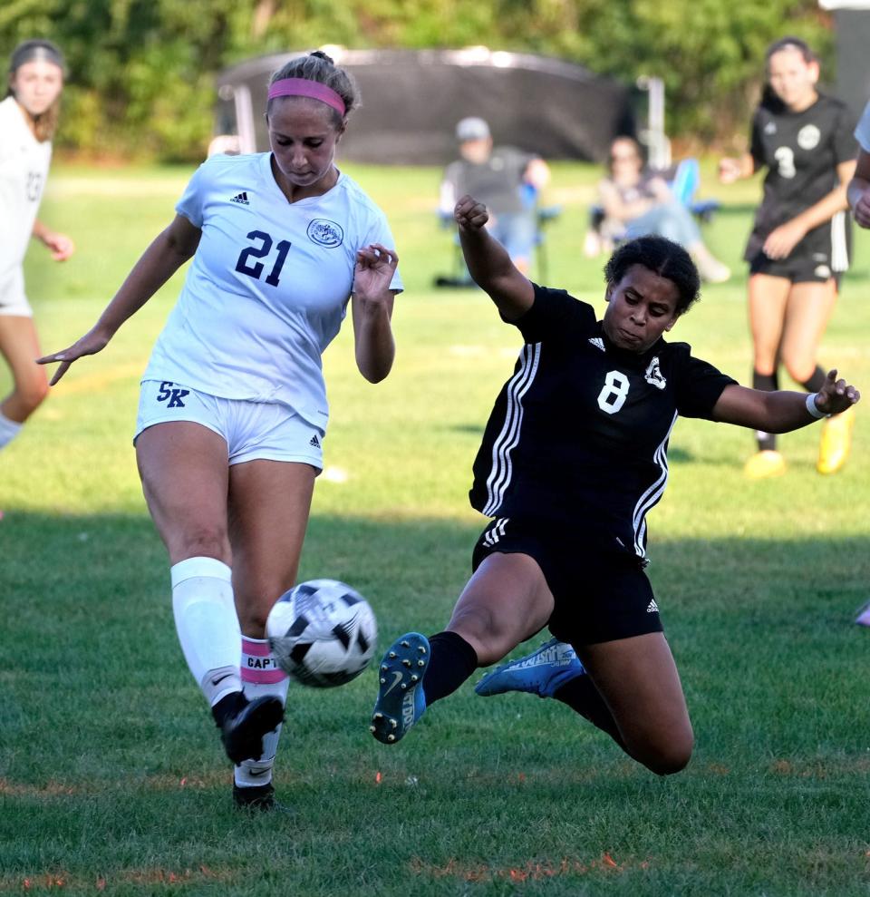 Pilgrim's Amaya Coffie slides in on South Kingstown Rebel Lauren Fewlass trying to steal the ball in a match last fall.